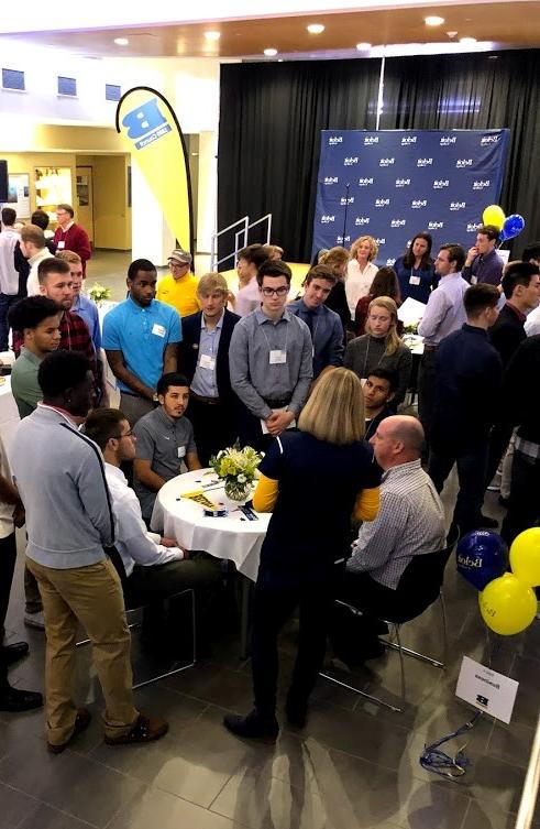 A group of student athletes gather around Kathy Selck '98, Hall of Honor member.