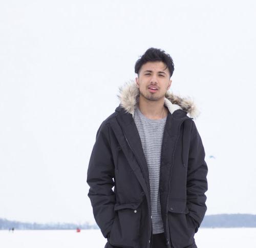 Sahil Rizal'11 at a frozen lake, with ice fishers in the background