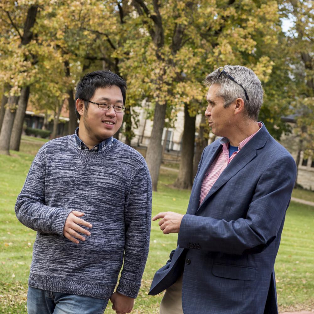 Professor of Modern Languages & Literatures Daniel Youd walks with Weining Wang'21 across cam...