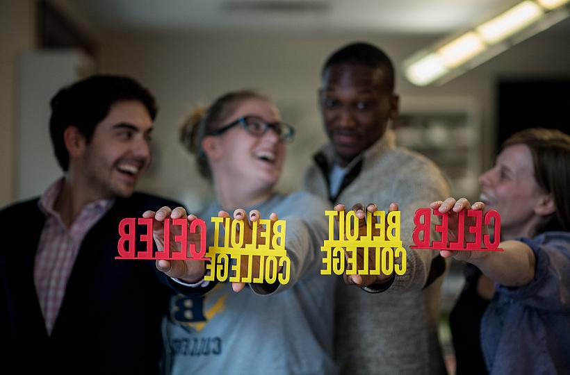 Students are holding signs that were made with a 3D printer in CELEB's Maker Lab, which will move to the renovated building's third floor...