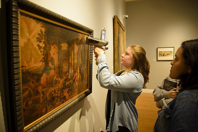 Chemistry major Sarah Farr'19 shoots a handheld X-Ray fluorescence analyzer at a painting in the Wright Museum of Art's permanent collection.